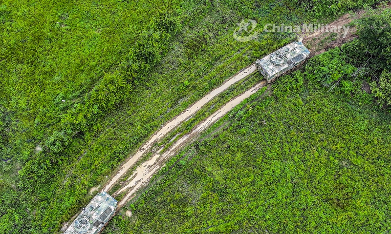 Two armored vehicles attached to a brigade under the PLA 73rd Group Army march forward en route to a designated training field. The training was organized in special terrain conditions and simulated real-combat environment, aiming to test the troops’ comprehensive combat capability in unfamiliar environments and emergency situations. (eng.chinamil.com.cn/Photo by Liu Zhiyong)