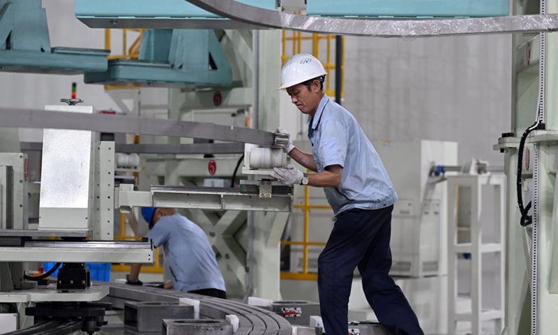 Staff members adjust and test equipment used in the Toroidal Field Coil Turn Insulation Automatic Wrapping System in the park of Comprehensive Research Facility for Fusion Technology (CRAFT) in Hefei, east China's Anhui Province, Sept. 15, 2023. (Xinhua/Zhou Mu)