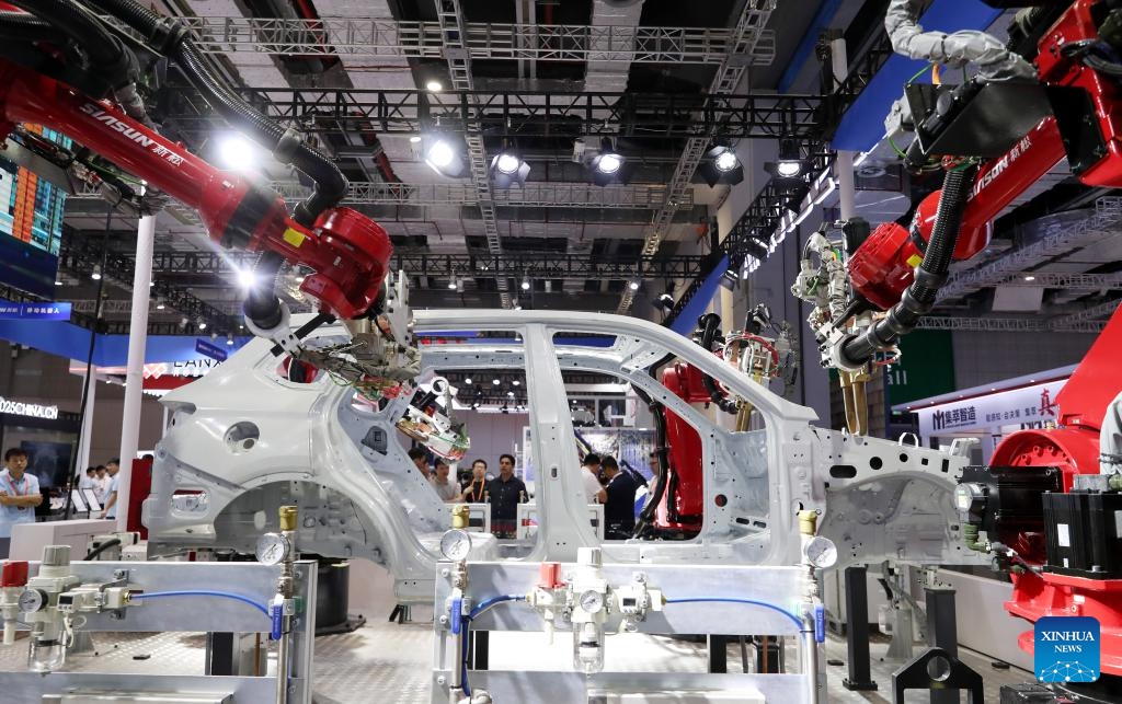 Visitors watch a robot welding an auto body during the 23rd China International Industry Fair (CIIF) in east China's Shanghai, Sept. 19, 2023. The 23rd CIIF kicked off here on Tuesday, with the theme of Digital Economy & Industrial Decarbonization.(Photo: Xinhua)