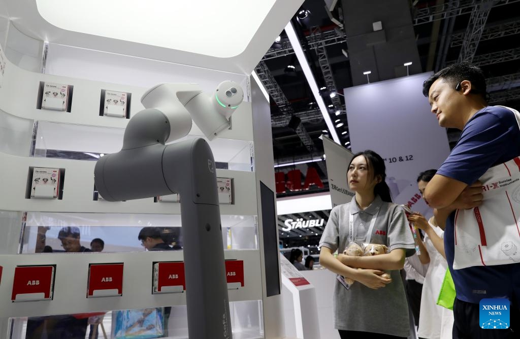 A service robot serves a visitor (R) during the 23rd China International Industry Fair (CIIF) in east China's Shanghai, Sept. 19, 2023. The 23rd CIIF kicked off here on Tuesday, with the theme of Digital Economy & Industrial Decarbonization.(Photo: Xinhua)