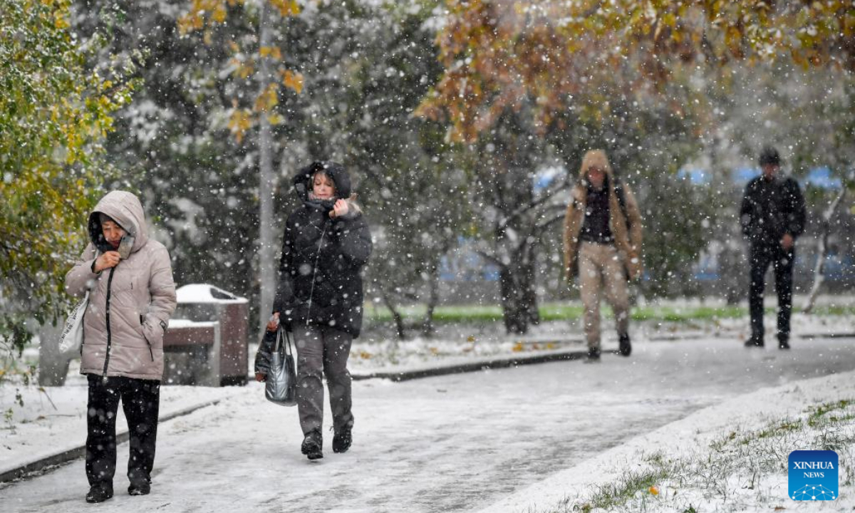 People walk amid snowfall in Moscow, Russia, on Oct 27, 2023. Photo:Xinhua