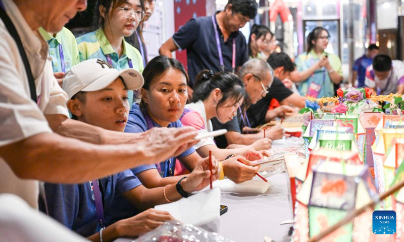 Members of Team Thailand experience traditional Chinese handicraft at the Asian Games Sub-village in Chun'an, east China's Zhejiang Province, Sept. 25, 2023. (Xinhua/Hu Huhu)