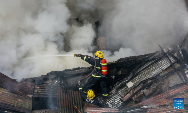 Firefighters try to put out a fire at a residential area in Quezon City, the Philippines on Oct. 15, 2023. (Xinhua/Rouelle Umali)