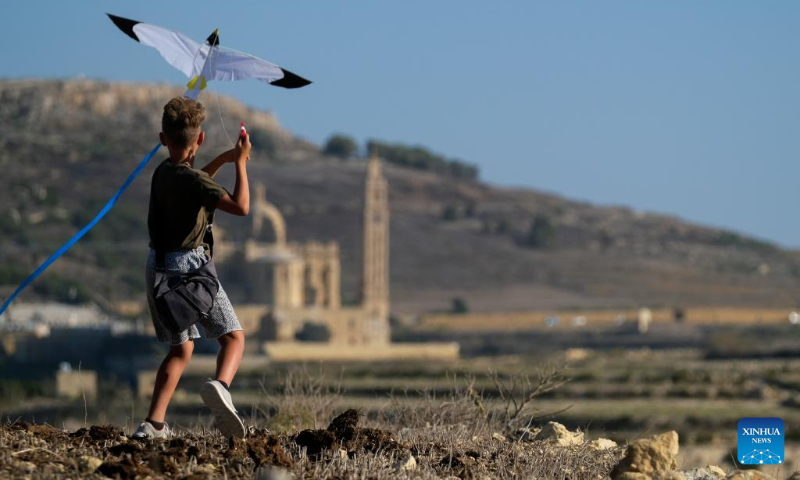 A boy flies a kite during the 6th edition of the International Kite and Wind Festival in the village of Gharb on the island of Gozo, Malta, on Oct. 15, 2023. (Photo by Jonathan Borg/Xinhua)