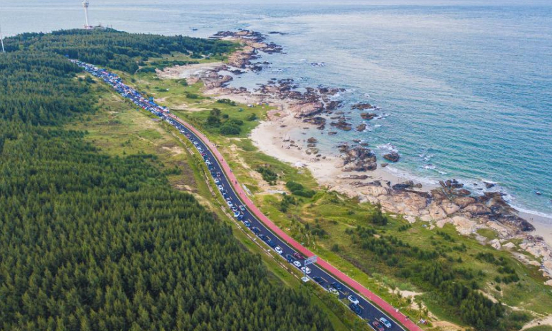 This aerial photo taken on Oct. 4, 2023 shows vehicles for self-driving tours and the scenery along a scenic coastal highway in Wenchang, south China's Hainan Province. The opened section of the scenic coastal highway in Hainan have attracted numerous tourists for self-driving tours during the Mid-Autumn Festival and National Day holiday. (Xinhua/Pu Xiaoxu)