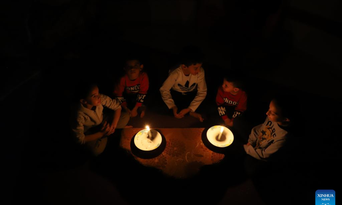 Children use candles for lighting in the southern Gaza Strip city of Khan Younis, on Oct. 20, 2023. The Palestinian Islamic Resistance Movement (Hamas) launched a surprise attack on Israel on Oct 7, firing thousands of rockets and infiltrating Israeli territory, to which Israel responded with massive airstrikes and punitive measures, including a siege on the enclave with supplies of water, electricity, fuel, and other necessities being cut off. Photo:Xinhua