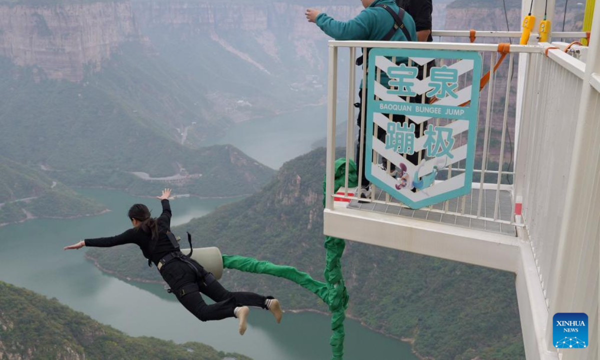 A tourist experiences bungee jump at the Baoquan scenic spot in Huixian, central China's Henan Province, on Oct 19, 2023. Photo:Xinhua