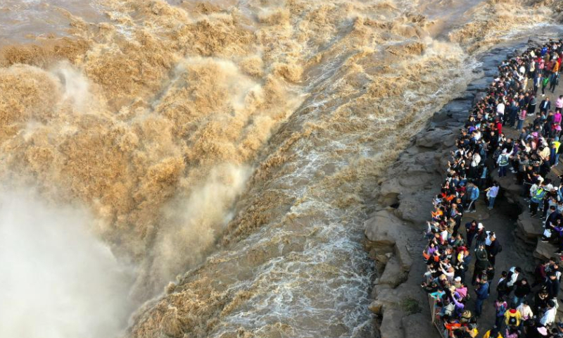 This aerial photo taken on Oct. 3, 2023 shows tourists enjoying the scenery of the Hukou Waterfall on the Yellow River, on the border area between north China's Shanxi and northwest China's Shaanxi provinces.

The Mid-Autumn Festival and National Day holiday period, which lasts from Sept. 29 to Oct. 6 this year, is a peak travel and tourism season in China. (Photo by Lyu Guiming/Xinhua)