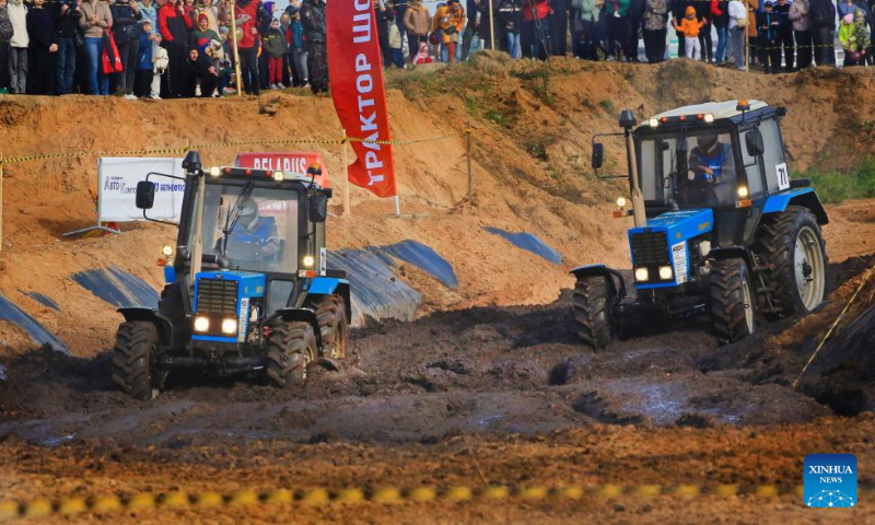 This photo taken on Oct. 14, 2023 shows competitors driving tractors during a tractor show in Minsk, Belarus. Belarusian tractor industry celebrated its 70th anniversary on Saturday with a tractor show held at the Great Stone China-Belarus Industrial Park in Minsk. (Photo by Henadz Zhinkov/Xinhua)