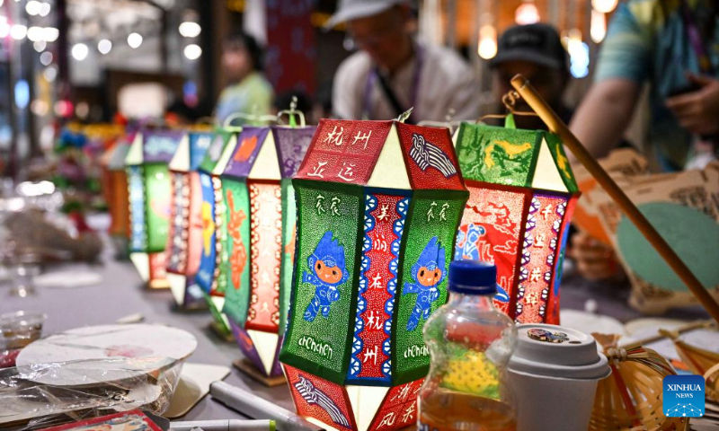 Members of different delegations experience traditional Chinese handicraft at the Asian Games Sub-village in Chun'an, east China's Zhejiang Province, Sept. 25, 2023. (Xinhua/Hu Huhu)