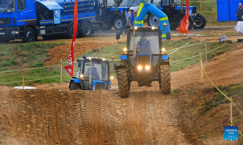 This photo taken on Oct. 14, 2023 shows competitors driving tractors during a tractor show in Minsk, Belarus. Belarusian tractor industry celebrated its 70th anniversary on Saturday with a tractor show held at the Great Stone China-Belarus Industrial Park in Minsk. (Photo by Henadz Zhinkov/Xinhua)