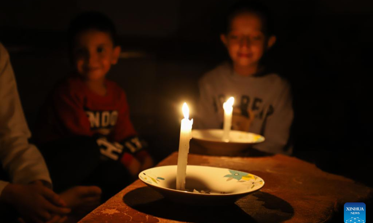 Children use candles for lighting in the southern Gaza Strip city of Khan Younis, on Oct. 20, 2023. The Palestinian Islamic Resistance Movement (Hamas) launched a surprise attack on Israel on Oct 7, firing thousands of rockets and infiltrating Israeli territory, to which Israel responded with massive airstrikes and punitive measures, including a siege on the enclave with supplies of water, electricity, fuel, and other necessities being cut off. Photo:Xinhua