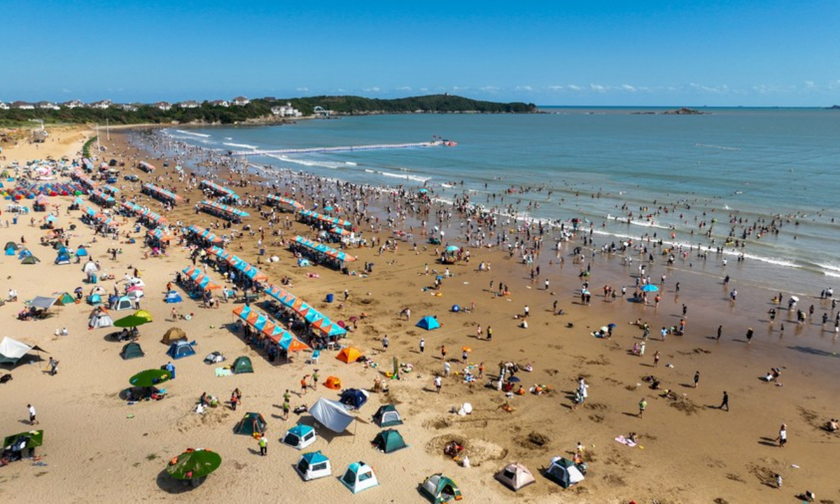 This aerial photo taken on Oct 3, 2023 shows tourists enjoying themselves along a beach in Zhoushan City, east China's Zhejiang Province. Photo:Xinhua