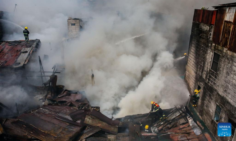 Firefighters try to put out a fire at a residential area in Quezon City, the Philippines on Oct. 15, 2023. (Xinhua/Rouelle Umali)