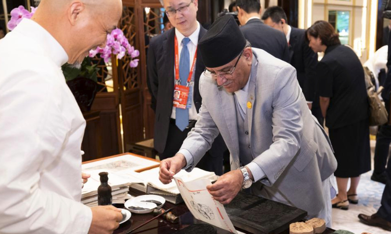 Nepalese Prime Minister Pushpa Kamal Dahal Prachanda participates in an activity demonstrating intangible cultural heritages before a welcoming banquet in Hangzhou, capital city of east China's Zhejiang Province, Sept. 23, 2023. (Xinhua/Huang Jingwen)

