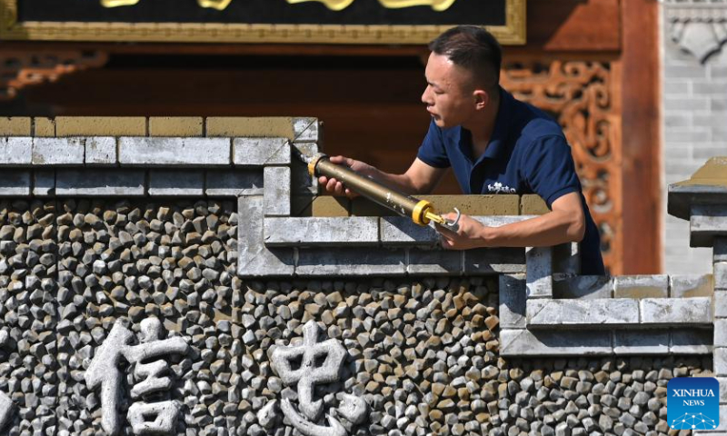 Villager Li Tan'en works at a theater in Qikou ancient town of Linxian County, north China's Shanxi Province, Aug. 2, 2023. In 2020, Li ended his career as a migrant worker and served as a staff member for a local theater in the Qikou ancient town. The job brings him an annual income of more than 50,000 yuan (about 6,848 U.S. dollars). Qikou, an ancient riverine town along the Yellow River, was an important trade ferry in history. However, with the development of land transportation, the Qikou ancient town declined in terms of trade volume, leaving many of its historical buildings in disrepair. In recent years, local authorities have carried out protection and restoration of historical buildings and ancient dwellings in the Qikou ancient town. At the same time, the integrated development of culture and tourism is also promoted. Today the ancient town has become a popular tourist attraction. More than 5,000 people out of a population of about 30,000 in the town are engaged in the tourism industry. （Photo：Xinhua）