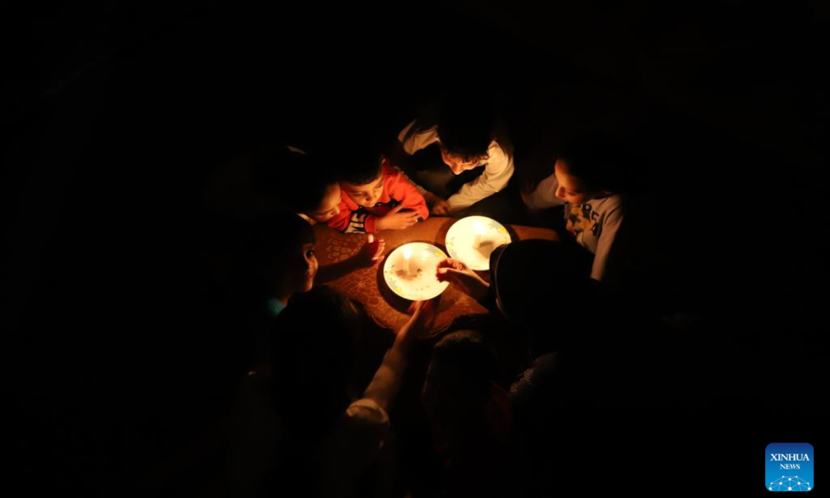 Children use candles for lighting in the southern Gaza Strip city of Khan Younis, on Oct. 20, 2023. The Palestinian Islamic Resistance Movement (Hamas) launched a surprise attack on Israel on Oct 7, firing thousands of rockets and infiltrating Israeli territory, to which Israel responded with massive airstrikes and punitive measures, including a siege on the enclave with supplies of water, electricity, fuel, and other necessities being cut off. Photo:Xinhua