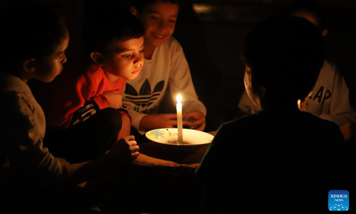 Children use candles for lighting in the southern Gaza Strip city of Khan Younis, on Oct. 20, 2023. The Palestinian Islamic Resistance Movement (Hamas) launched a surprise attack on Israel on Oct 7, firing thousands of rockets and infiltrating Israeli territory, to which Israel responded with massive airstrikes and punitive measures, including a siege on the enclave with supplies of water, electricity, fuel, and other necessities being cut off. Photo:Xinhua