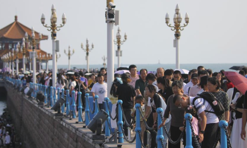 Tourists visit Zhanqiao scenic area in Qingdao, east China's Shandong Province, Oct. 3, 2023.

The Mid-Autumn Festival and National Day holiday period, which lasts from Sept. 29 to Oct. 6 this year, is a peak travel and tourism season in China. (Photo by Huang Jiexian/Xinhua)