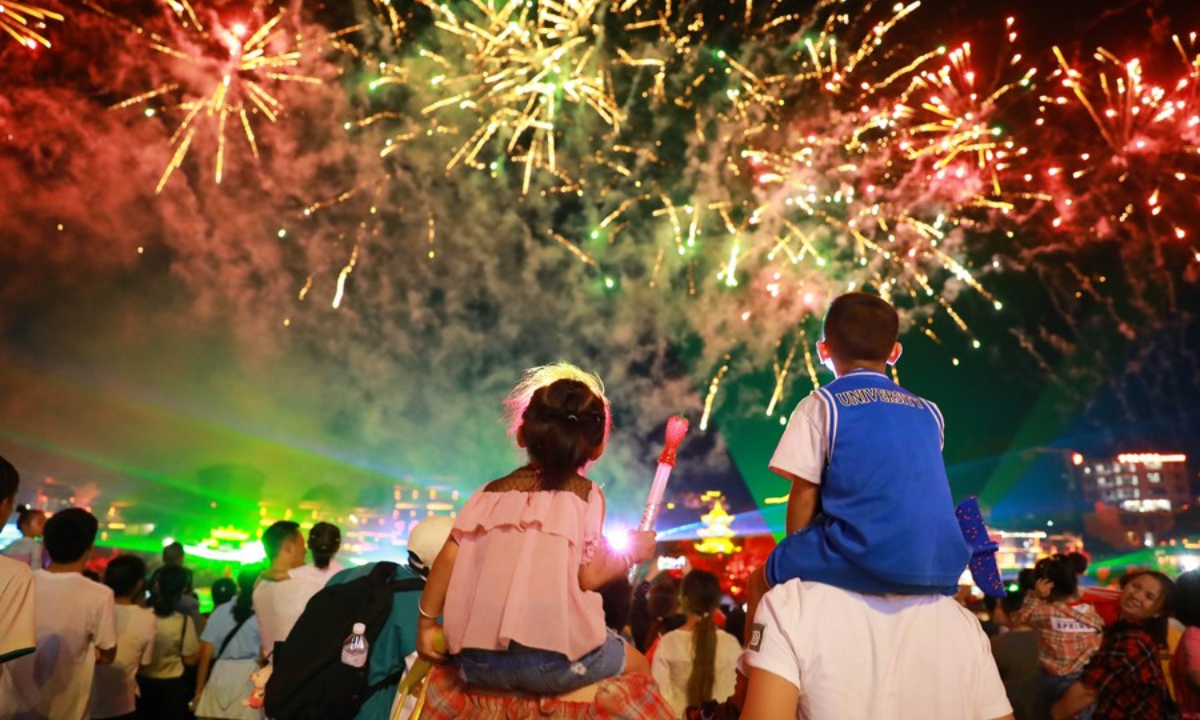 Tourists watch a firework show in Kaili City of Qiandongnan Miao and Dong Autonomous Prefecture, southwest China's Guizhou Province, Oct 1, 2023. Photo:Xinhua