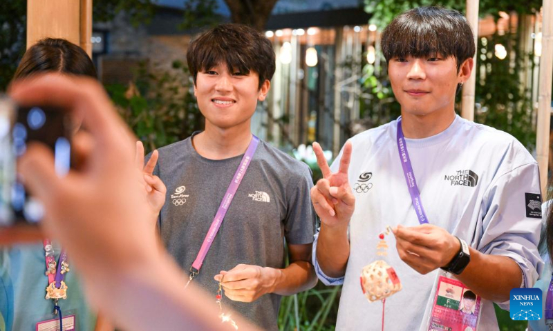 Members of Team South Korea pose for photos after experiencing traditional Chinese handicraft at the Asian Games Sub-village in Chun'an, east China's Zhejiang Province, Sept. 25, 2023. (Xinhua/Hu Huhu)