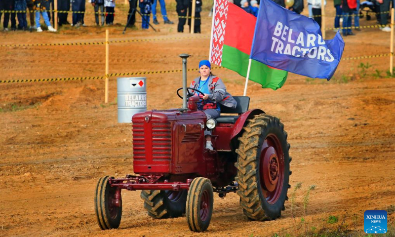 This photo taken on Oct. 14, 2023 shows a competitor driving a tractor during a tractor show in Minsk, Belarus. Belarusian tractor industry celebrated its 70th anniversary on Saturday with a tractor show held at the Great Stone China-Belarus Industrial Park in Minsk. (Photo by Henadz Zhinkov/Xinhua)