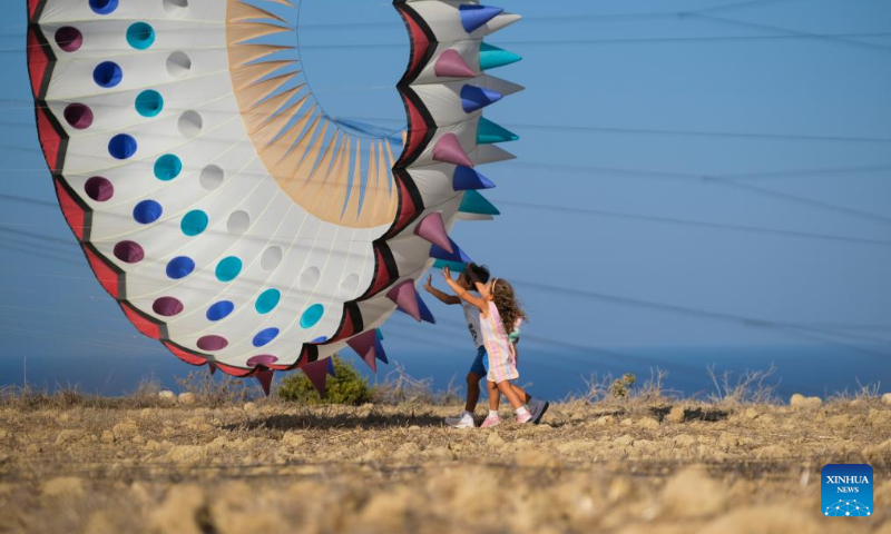 Kids fly a kite during the 6th edition of the International Kite and Wind Festival in the village of Gharb on the island of Gozo, Malta, on Oct. 15, 2023. (Photo by Jonathan Borg/Xinhua)