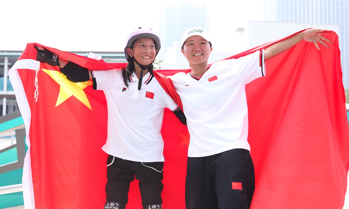 Cui Chenxi (left) and Zeng Wenhui pose for photos after the women's street final of skateboarding at the Hangzhou Asian Games on September 27, 2023. Photo: VCG