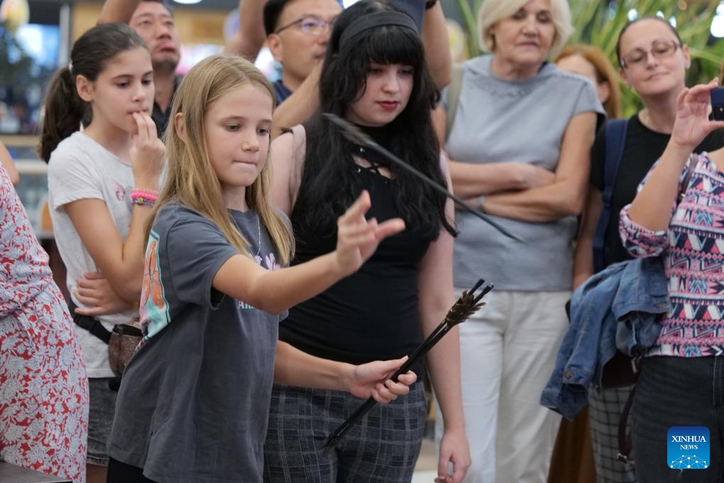 A Serbian girl plays Touhu game, or Pitch-pot, an ancient Chinese entertainment, during a Chinese culture event in the north-central Serbian city of Novi Sad, Sept. 23, 2023. This cultural event was hosted on Saturday by the Confucius Institute at the University of Novi Sad, attracting many local citizens.(Photo: Xinhua)