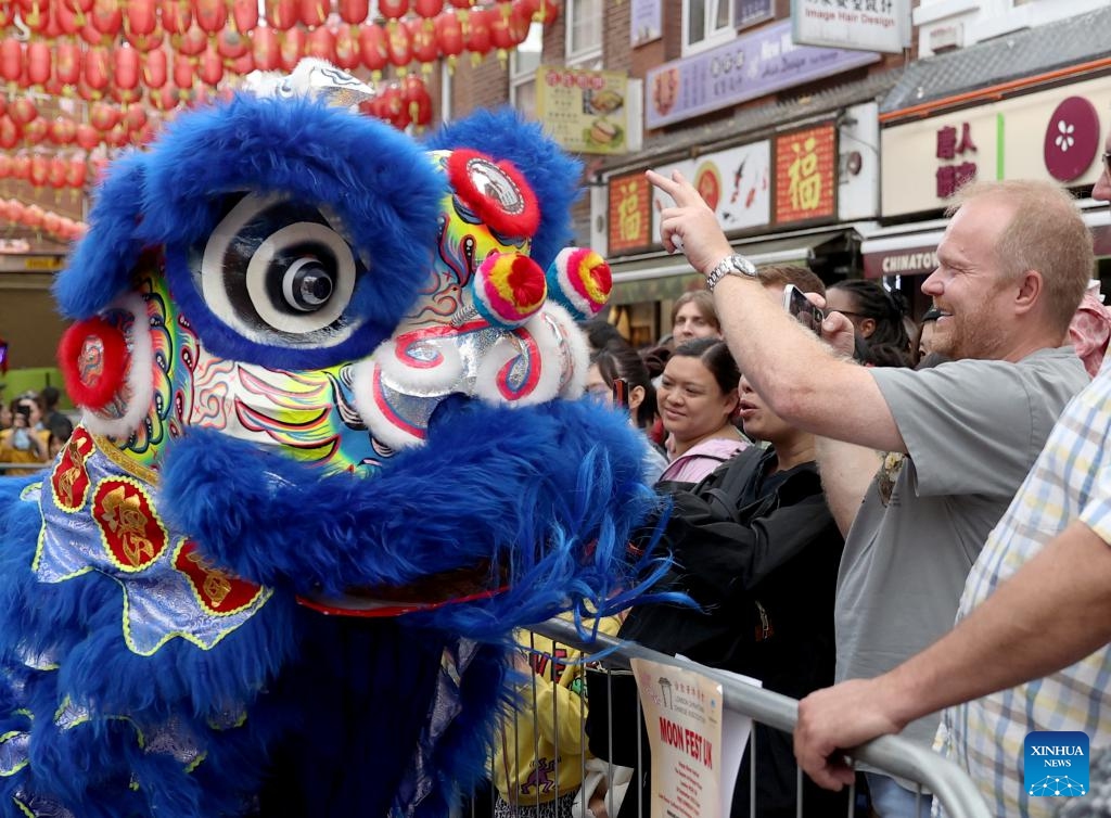 Locals watch a lion dance performance at a show for the celebration of the Chinese Mid-Autumn Festival in London, Britain, Sept. 24, 2023. (Photo: Xinhua)