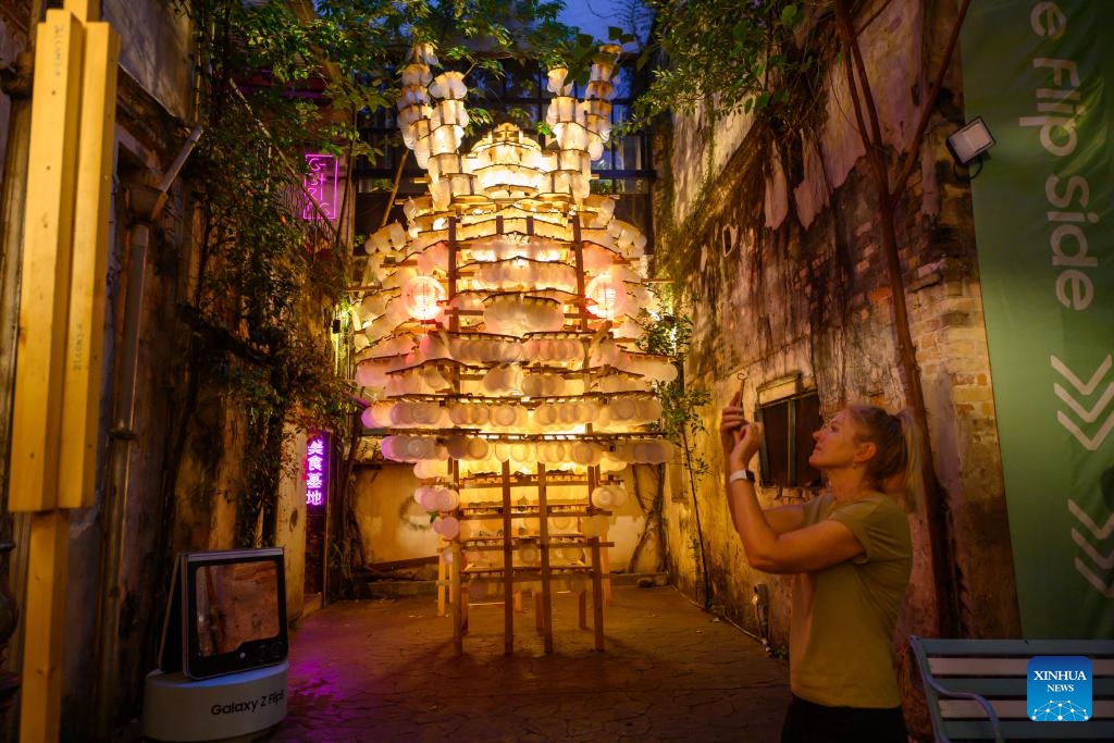 A woman takes pitures of lanterns installed for the upcoming Mid-Autumn Festival at Kwai Chai Hong in Kuala Lumpur, Malaysia, Sept. 23, 2023. The upcoming Mid-Autumn Festival features prominently in multicultural Malaysia, with the overseas Chinese and their local friends enthusiastically marking the key cultural date.(Photo: Xinhua)