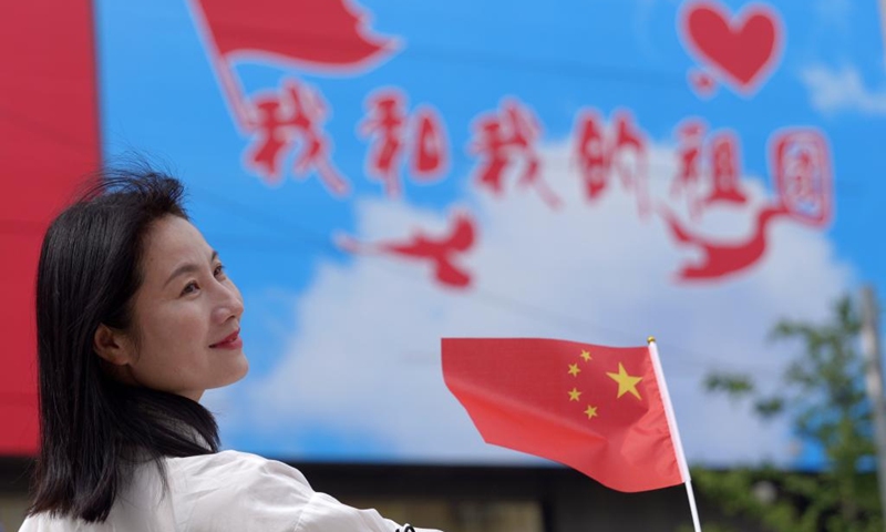 A woman poses for a photo in Zhengzhou, central China's Henan Province, Oct. 1, 2023. People across the country enjoy themselves in various way on the first day of the National Day holiday. (Xinhua/Li Jianan)