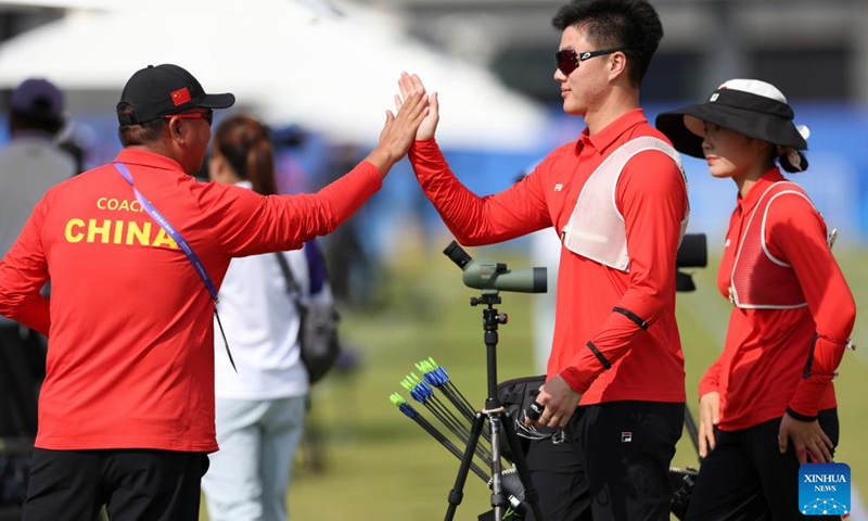 Wei Shaoxuan (C) of China claps hands with his coach after the Recurve Mixed Team 1/8 Elimination of Archery between team China and team China's Hong Kong at the 19th Asian Games in Hangzhou, east China's Zhejiang Province, Oct. 2, 2023. (Xinhua/Meng Chenguang)