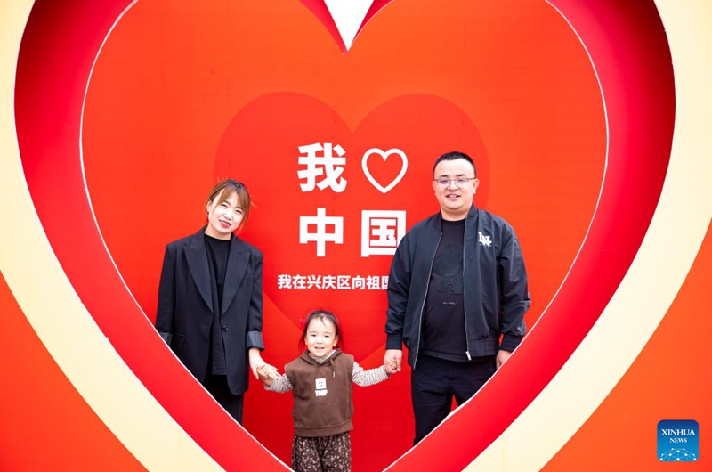 People pose for a photo near the drum tower in Yinchuan, northwest China's Ningxia Hui Autonomous Region, Oct. 1, 2023. People across the country enjoy themselves in various way on the first day of the National Day holiday. (Xinhua/Yang Zhisen)