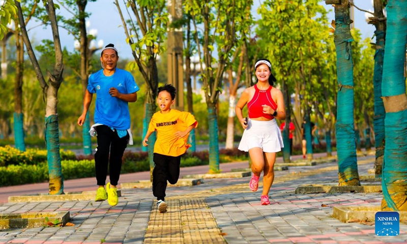 People jog along a road in Liancheng subdistrict in Qianxi City of southwest China's Guizhou Province, Oct. 1, 2023. People across the country enjoy themselves in various way on the first day of the National Day holiday. (Photo by Zhou Xunchao/Xinhua)