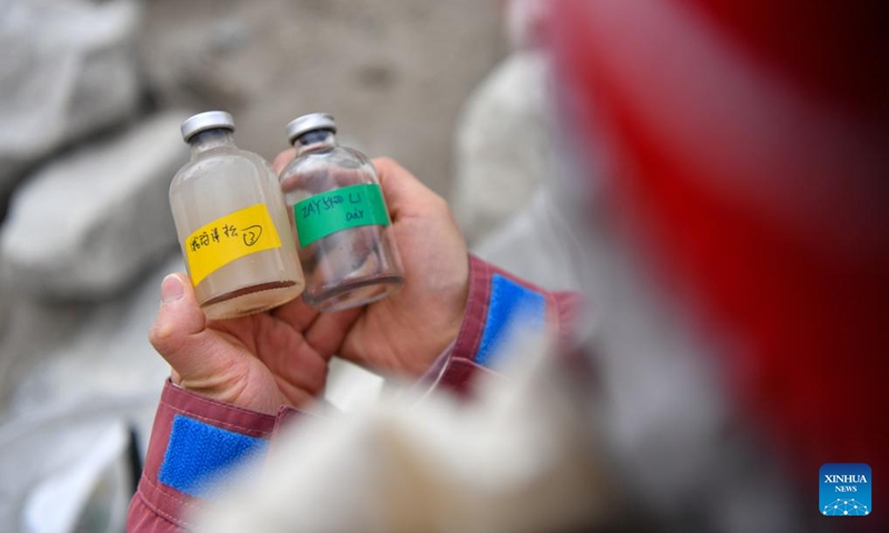 A member of a Chinese expedition team checks the water samples collected from a proglacial lake in the Mount Cho Oyu region on Oct. 1, 2023. An 18-member expedition team successfully reached on Sunday the summit of Mount Cho Oyu, also known as Mt. Qowowuyag, which soars to 8,201 meters above sea level, to carry out scientific research. It was the first time Chinese scientists scaled a peak exceeding 8,000 meters in altitude apart from Mt. Qomolangma, the world's highest summit.  Photo: Xinhua