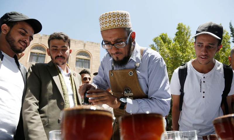 Visitors look at a barista making coffee at a coffee festival in Sanaa, Yemen, on Oct. 2, 2023. Yemen has a long history of coffee cultivation and consumption, and the beans here have a unique aroma due to the arid climate and abundant sunlight here. (Photo by Mohammed Mohammed/Xinhua)