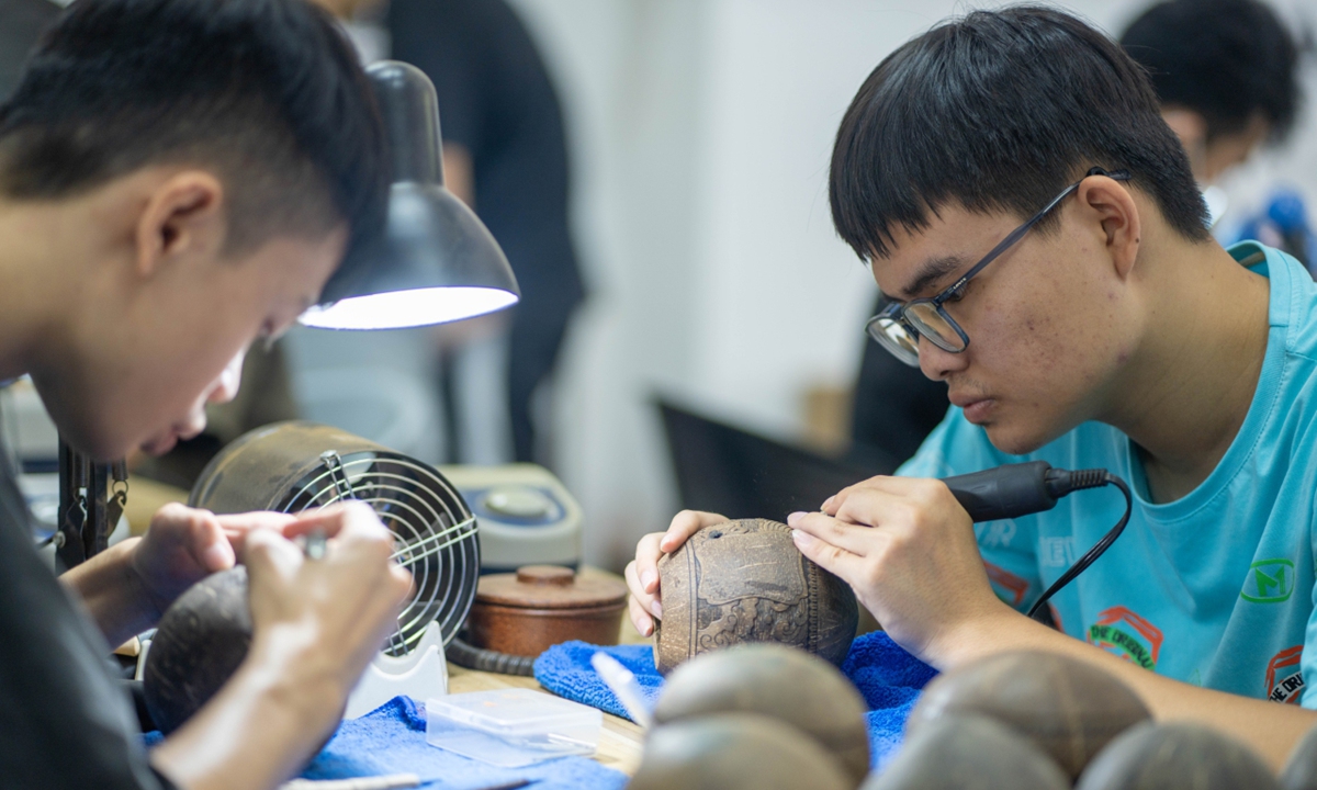 Workers are sculpting on coconut shells. Photo: Yuan Chen