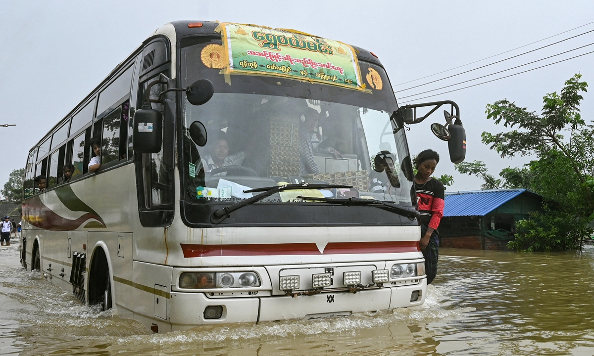 A bus drives through a flooded street in Hpa Yar Gyi in Myanmar's Bago region on October 9, 2023. Authorities said 200 millimeters of rain fell in the last 24 hours in the region, setting a new record for the month of October. Local officials said there were no casualties reported so far, but that more than 10,000 people had to abandon their homes. Photo: AFP