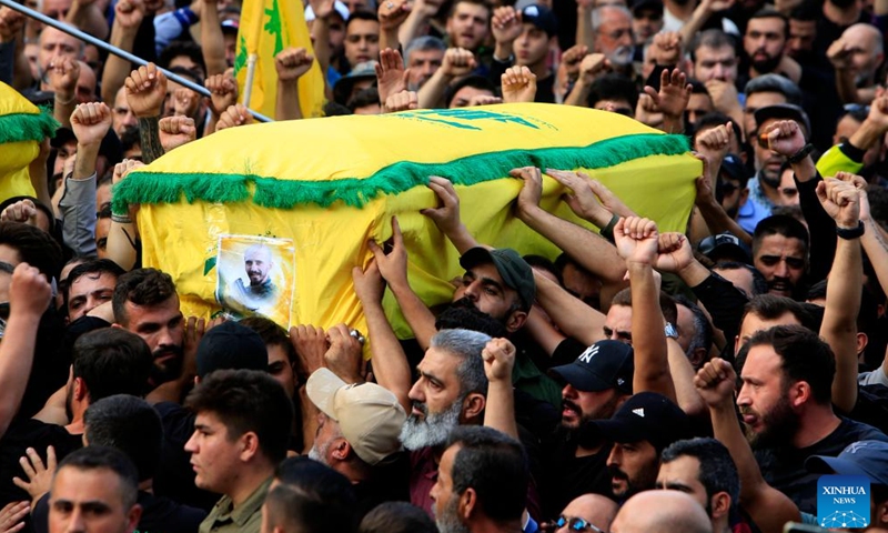 People carry a casket of a Hezbollah member killed in Israeli strikes during a funeral in the town of Khirbet Selm, southern Lebanon, on Oct. 10, 2023.(Photo: Xinhua)