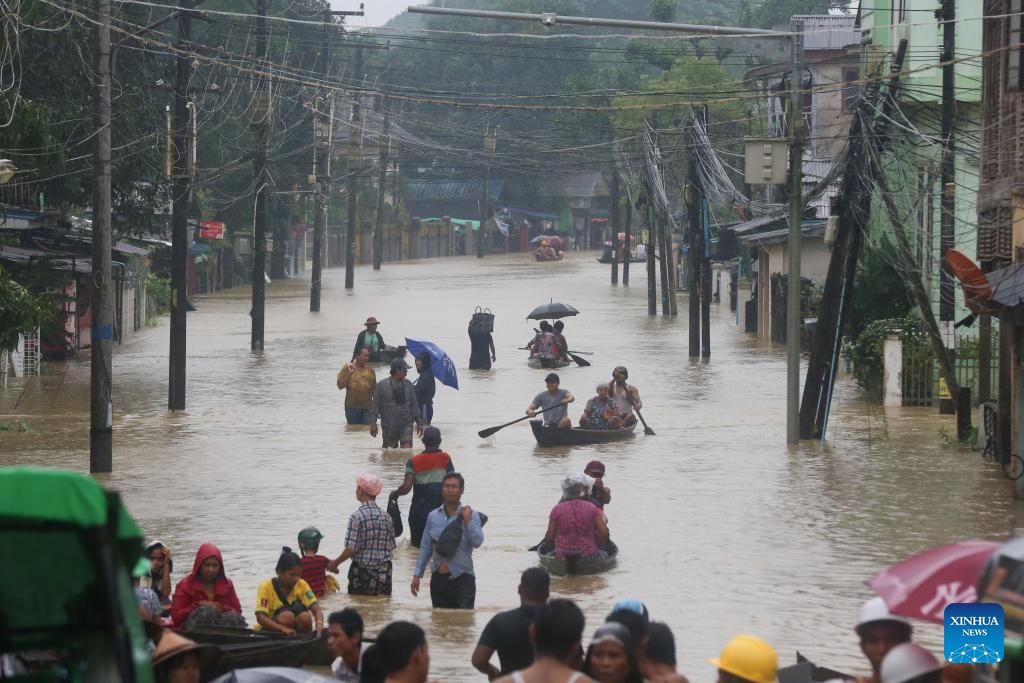 People wade through a flooded area in Bago Region of southern Myanmar, Oct. 10, 2023. Heavy rainfall hit Bago on Sunday.(Photo: Xinhua)