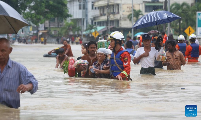 People wade through a flooded area in Bago Region of southern Myanmar, Oct. 10, 2023. Heavy rainfall hit Bago on Sunday.(Photo: Xinhua)