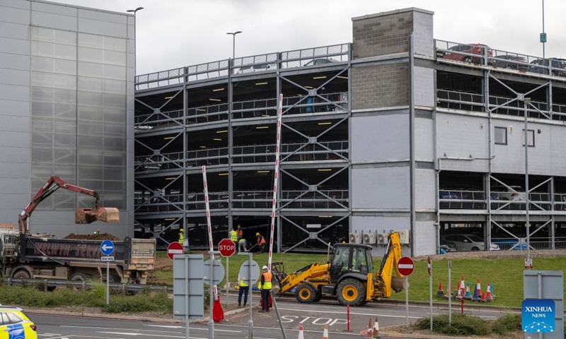 Fire crew members inspect the damage caused by a fire at the London Luton Airport's Terminal Car Park 2 in Britain, Oct. 11, 2023. All flights at London Luton Airport have been suspended until Wednesday afternoon after a massive blaze ripped through one of its car parks.(Photo: Xinhua)