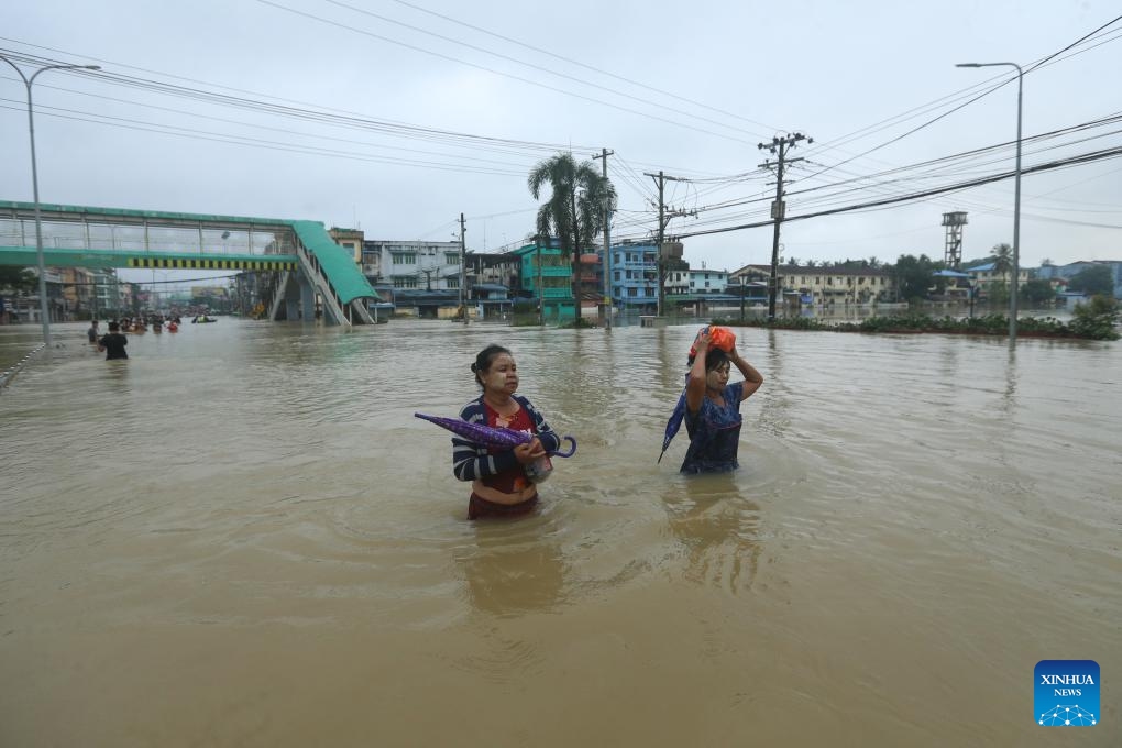 People wade through a flooded area in Bago Region of southern Myanmar, Oct. 10, 2023. Heavy rainfall hit Bago on Sunday.(Photo: Xinhua)