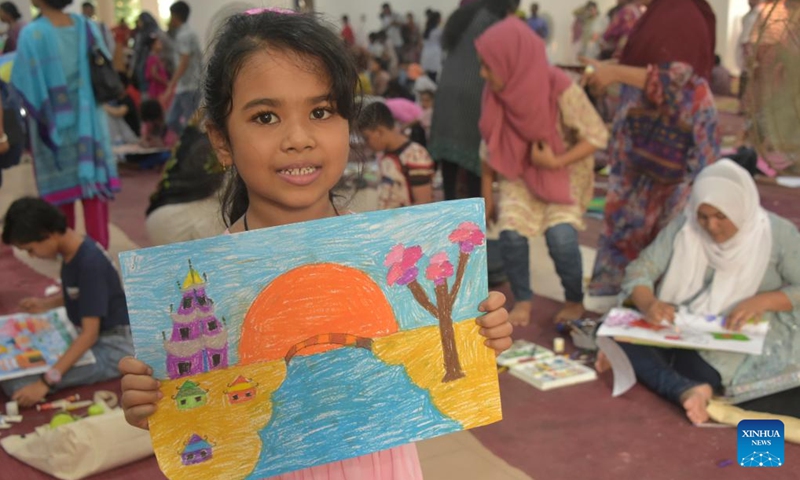 A girl shows her drawing during the 22nd Dreamland China Bangladesh Children Art Competition-2023 in Dhaka, Bangladesh, on Oct. 8, 2023. At the event, some 350 Bangladeshi children and juveniles depicted China in their drawings, featuring the Chinese national flag, the Great Wall and the Chinese-built Padma Bridge.(Photo: Xinhua)