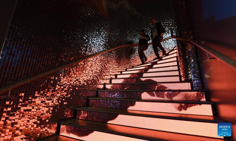 People walk down the stairs with a pattern featuring football at the FIFA Museum in Zurich, Switzerland, Oct. 12, 2023. The FIFA Museum in Zurich presents the exhibition Designing the Beautiful Game from Oct. 13, 2023.  (Photo: Xinhua)