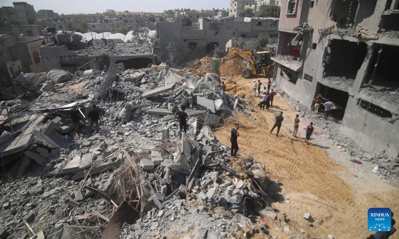 People inspect buildings destroyed in Israeli airstrikes in the southern Gaza Strip city of Rafah, on Oct. 12, 2023. The death toll of the Palestinians from the ongoing Israeli strikes on Gaza hit 1,417, while another 6,268 were wounded, according to the Gaza-based health ministry. (Photo: Xinhua)