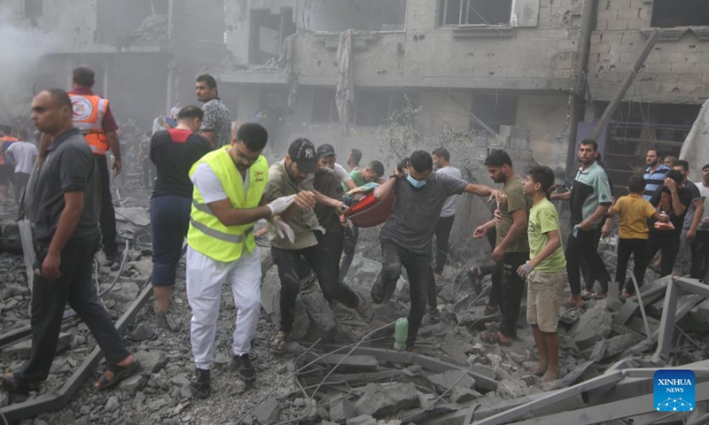 People rescue the injured at buildings destroyed in Israeli airstrikes in the southern Gaza Strip city of Rafah, on Oct. 12, 2023. The death toll of the Palestinians from the ongoing Israeli strikes on Gaza hit 1,417, while another 6,268 were wounded, according to the Gaza-based health ministry. (Photo: Xinhua)