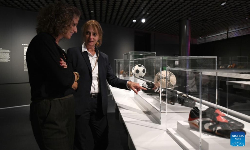 A staff member introduces exhibits during the press preview for the exhibition Designing the Beautiful Game at the FIFA Museum in Zurich, Switzerland, Oct. 12, 2023. The FIFA Museum in Zurich presents the exhibition Designing the Beautiful Game from Oct. 13, 2023. (Photo: Xinhua)