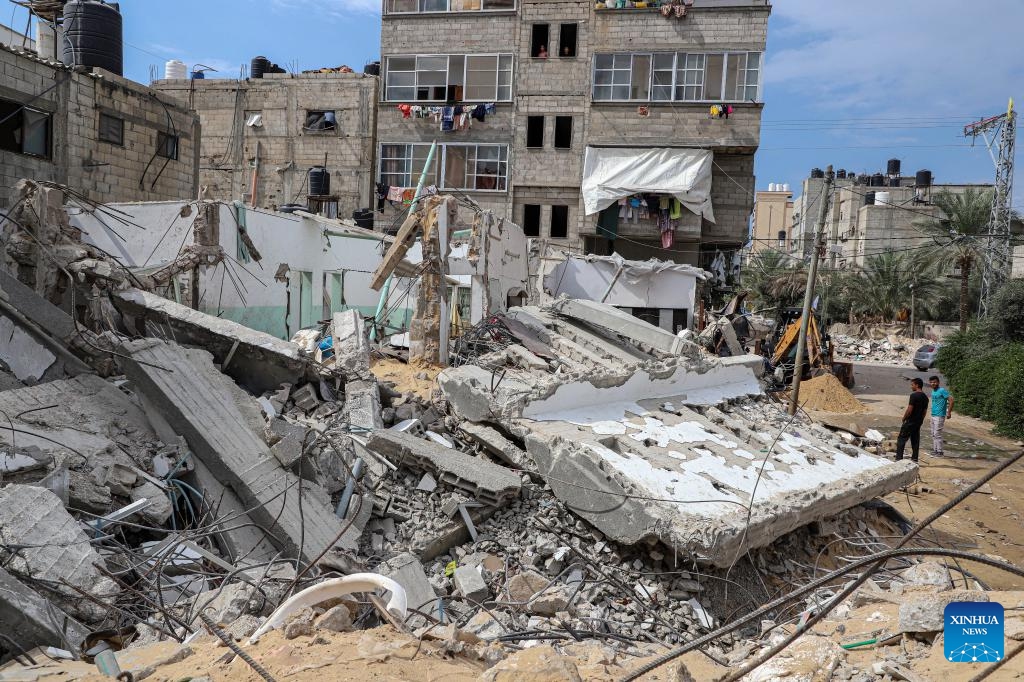 People inspect a building destroyed in Israeli airstrikes in the southern Gaza Strip city of Khan Younis, on Oct. 16, 2023. At least 2,750 Palestinians were killed by the Israeli army in Gaza, while in Israel, the death toll was at least 1,284 as of Sunday, according to official figures from the two sides.(Photo: Xinhua)